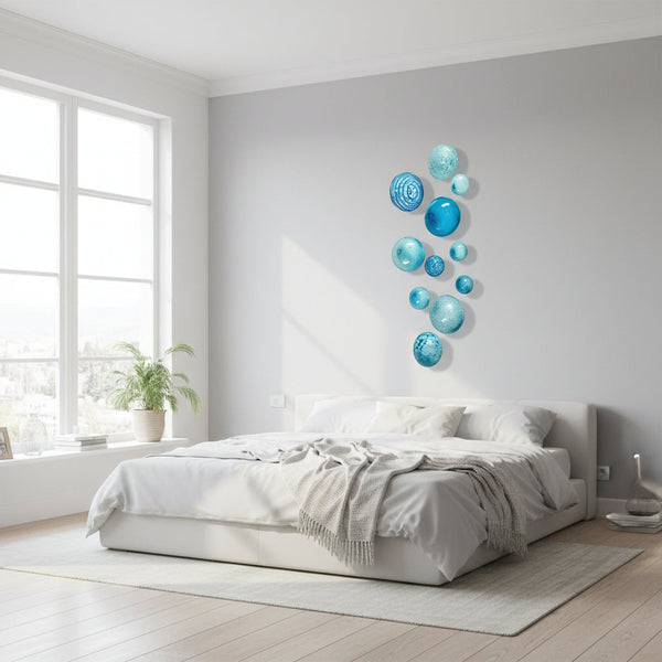 Blue glass marbles of various sizes on a white background